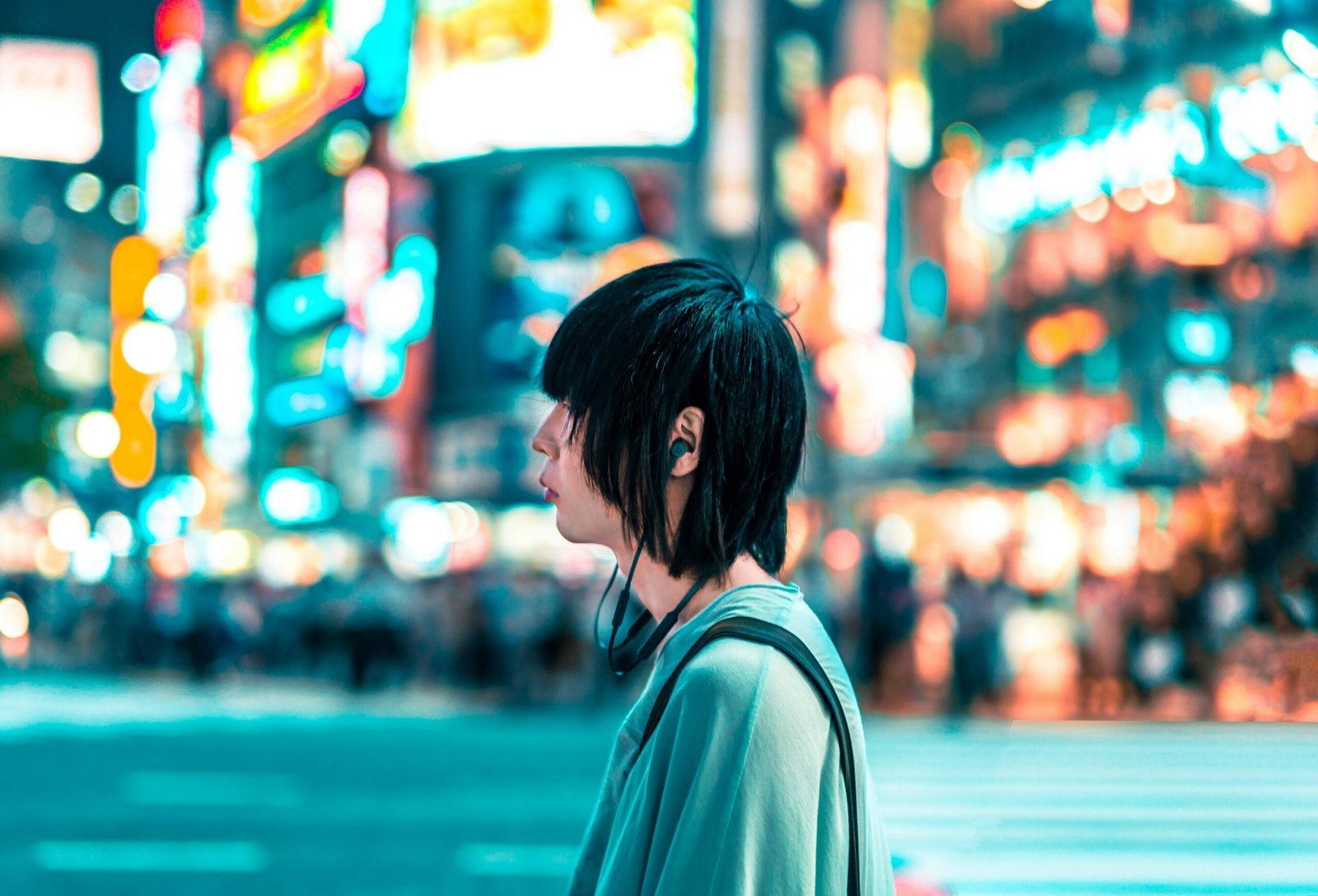 man in teal shirt using earphones